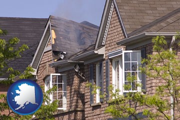 house fire damage with a smoldering roof - with Alaska icon