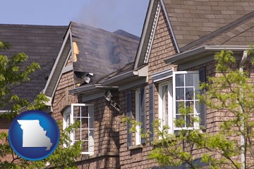 house fire damage with a smoldering roof - with Missouri icon