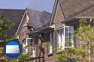 house fire damage with a smoldering roof - with North Dakota icon