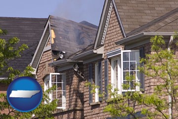 house fire damage with a smoldering roof - with Tennessee icon