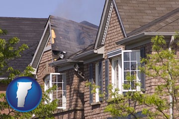 house fire damage with a smoldering roof - with Vermont icon