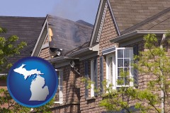 michigan map icon and house fire damage with a smoldering roof