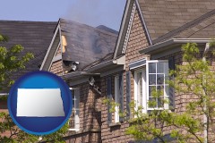 north-dakota map icon and house fire damage with a smoldering roof